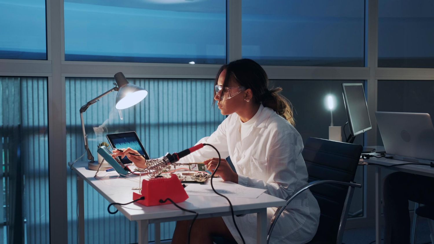 kobiety używającej laptopa przy oświetlonym stole