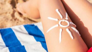 Dziewczyna nakładająca krem przeciwsłoneczny na swoje ciało