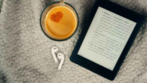 Czytnik e-booków, filiżanka kawy i słuchawka.