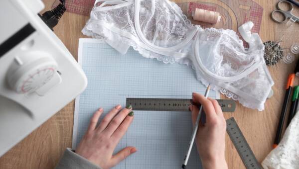 Widok z góry kobiecych dłoni rysuje projekt nowej kolekcji bielizny