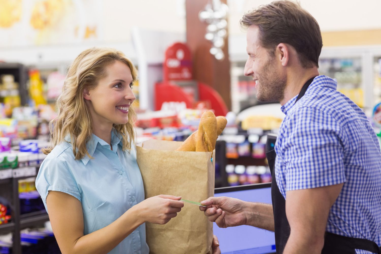 kobieta przy kasie płaci z kredytową kartą