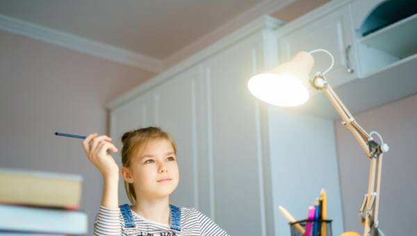 Portret szczęśliwego chłopca z zapaloną lampą w domu