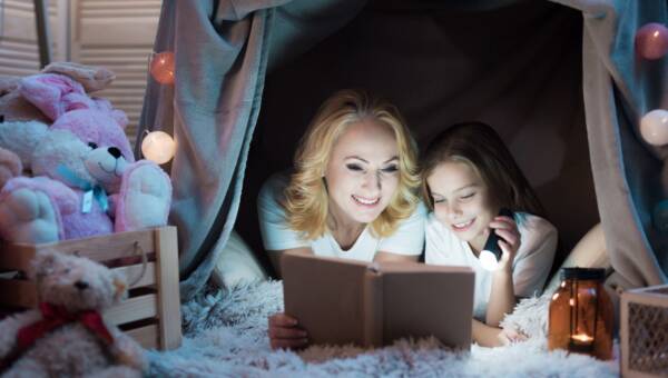 Babcia i wnuczka czytają książkę w nocy.