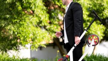 Elegancki mężczyzna niosący skuter