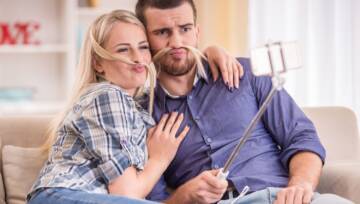 Para siedzi na kanapie w domu