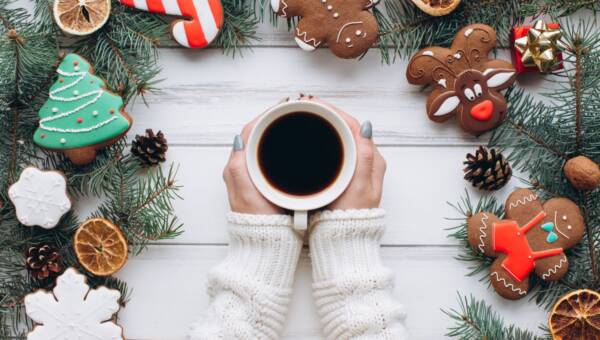 Kobieta trzyma filiżankę kawy z dekoracjami i miodownikiem