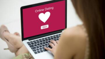 Młoda piękna samotna kobieta przeglądająca witrynę randkową online