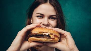 młoda dziewczyna je hamburgera