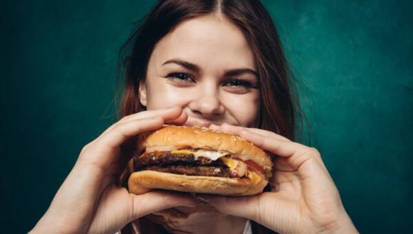 młoda dziewczyna je hamburgera