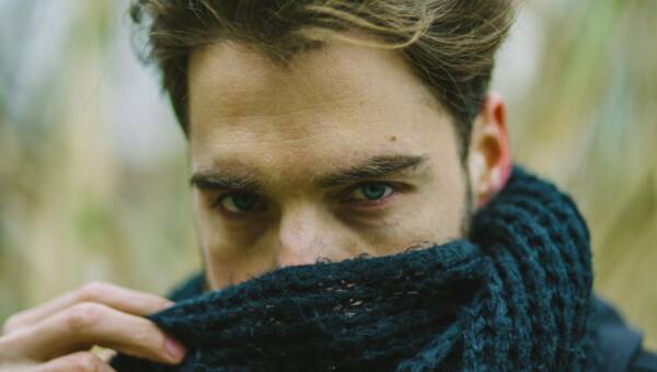 młody mężczyzna zasłania nos