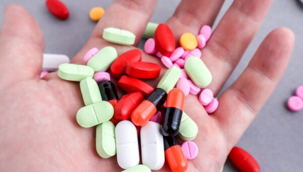 Garść kolorowych tabletek – ilustracja do artykułu o mechanizmach lekomanii i uzależnieniu od leków.