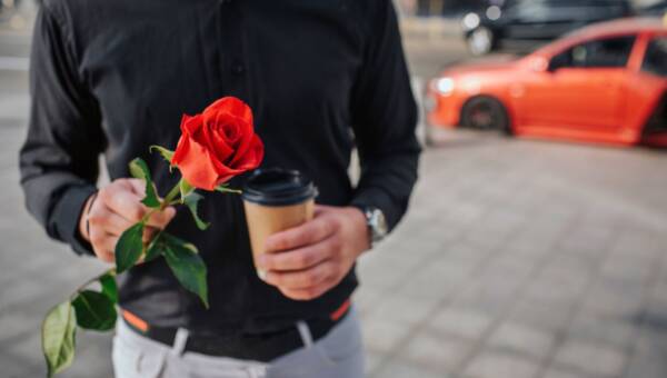 mężczyzna trzymający różę