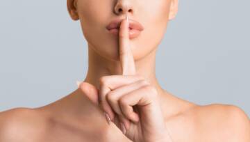 Kobieta trzymająca palec za wargi