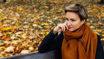 Portret krótkowłosej blondynki w terakotowej chustce w jesiennym parku