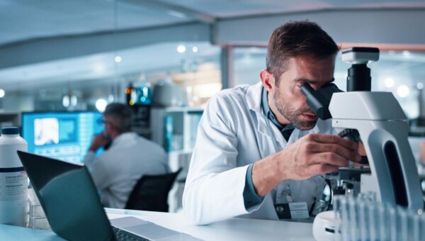 naukowiec badający plemniki w laboratorium pod mikroskopem