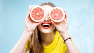 uśmiechnięta kobieta z plasterkami pomarańczy