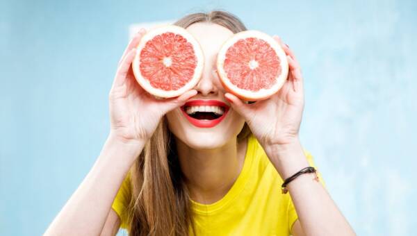 uśmiechnięta kobieta z plasterkami pomarańczy