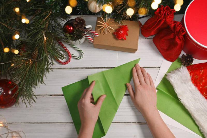 jeśli twój zielony arkusz papieru na wykonanie choinki posiada kształt pionowy, zegnij go odpowiednio jak na zdjęciu, by go dociąć i osiągnąć kształt kwadratu