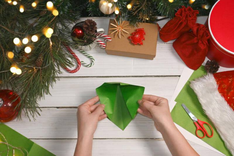 zegnij do wewnątrz dwie powstałe płaszczyzny, a następnie  tak, jak pokazano na zdjęciach aby uzyskać kształt trójkąta. Przytnij odpowiednio.