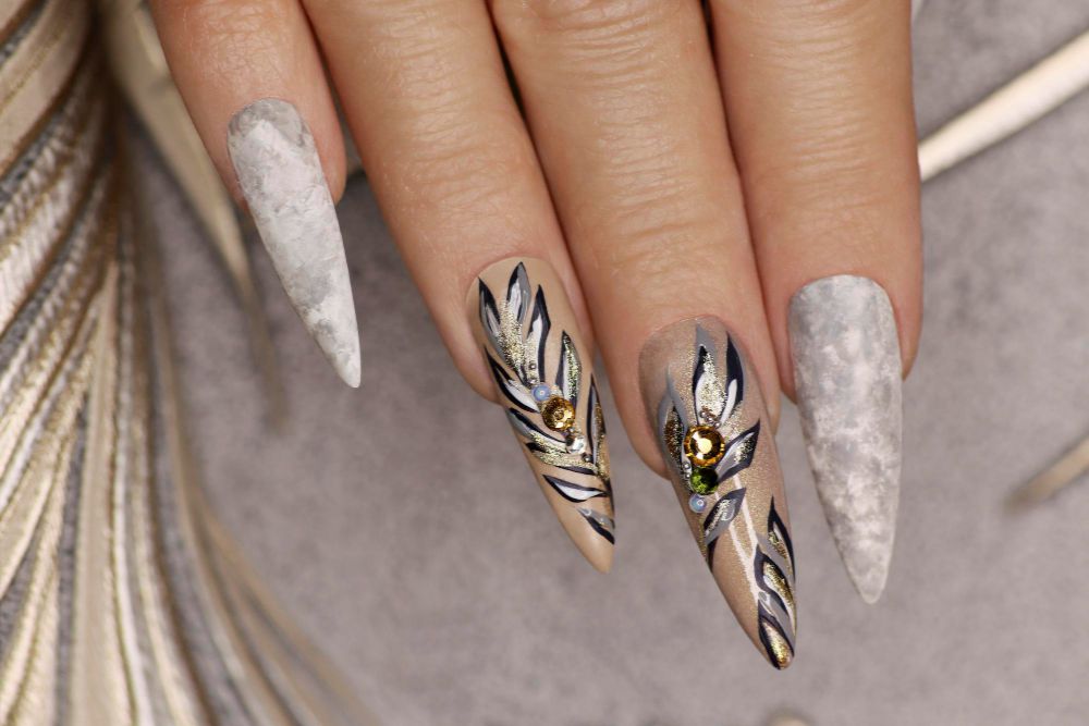 Paznokcie stiletto z motywem liści i cyrkoniami – letni manicure