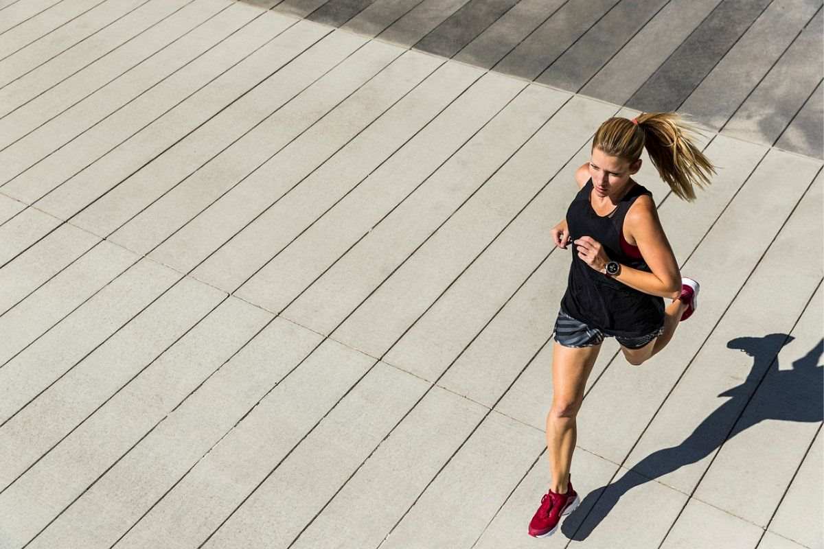 Kobieta uprawia jogging ze smartbandem na ręce