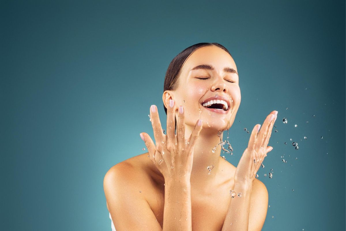 kobieta myje twarz wodą