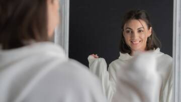 pewna siebie kobieta przegląda się w lustrze