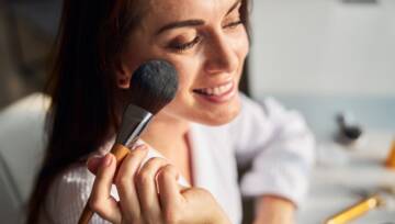 kobieta używa pudru do twarzy