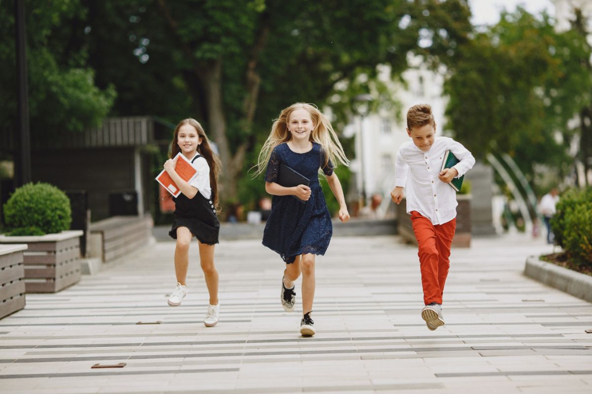 dzieci biegną przez park w pierwszy dzień wiosny