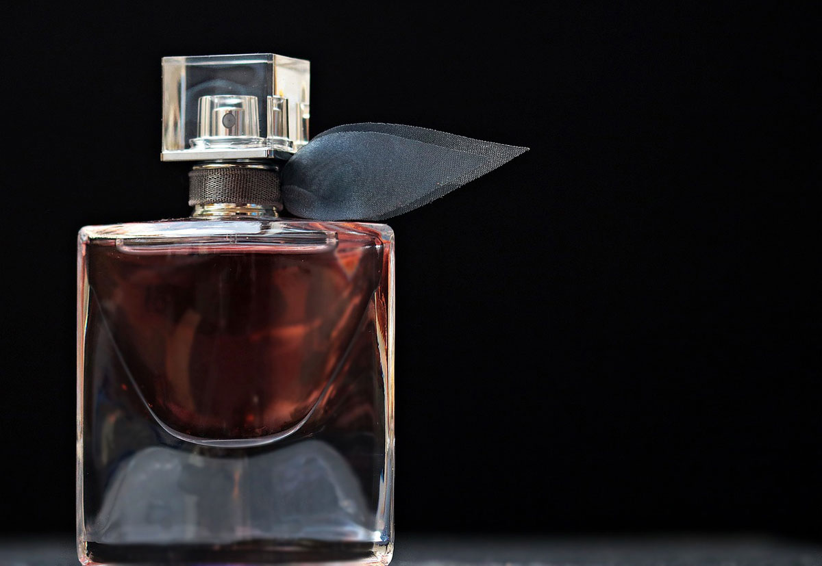 Przezroczysty flakon perfum na ciemnym tle