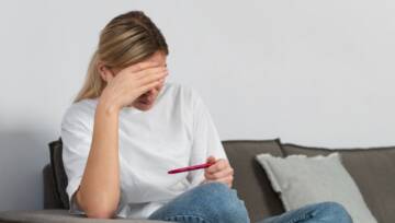 kobieta patrząca na test ciążowy