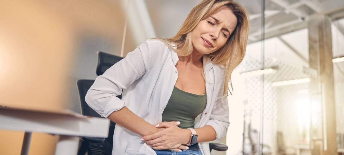 kobieta trzymająca się za bolący brzuch