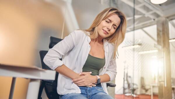 kobieta trzymająca się za bolący brzuch