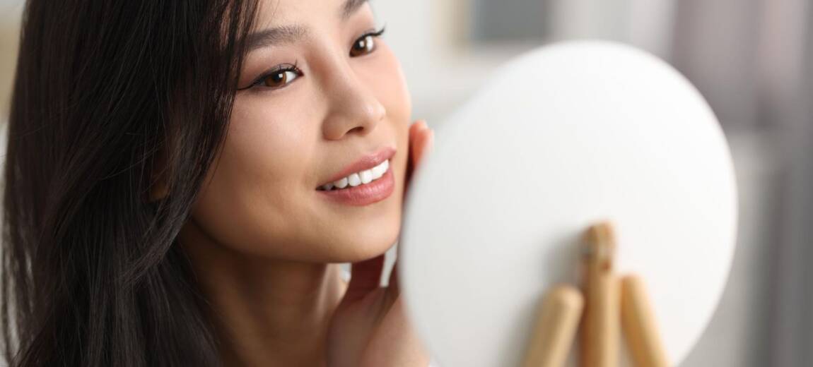 Atrakcyjna Koreanka prezentująca gładką cerę po zastosowaniu karnozyny w kosmetykach
