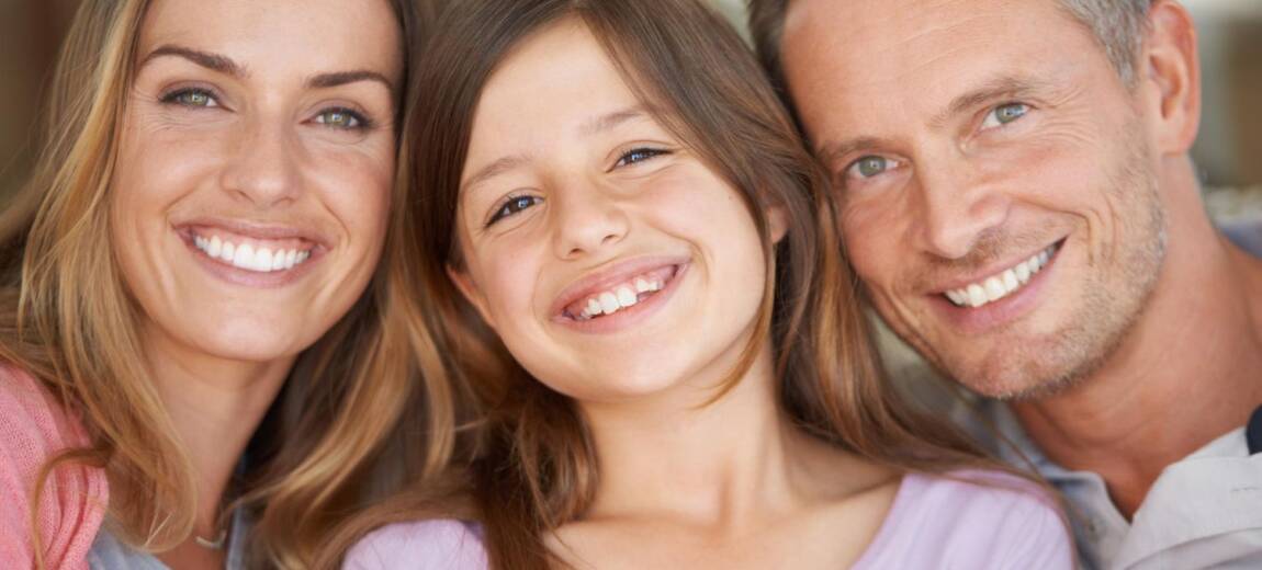 rodzina z pięknymi zębami uśmiechająca się