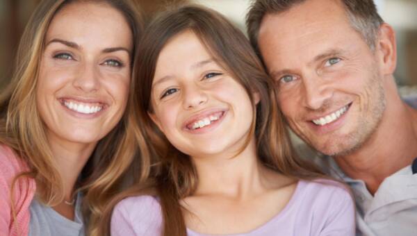 rodzina z pięknymi zębami uśmiechająca się
