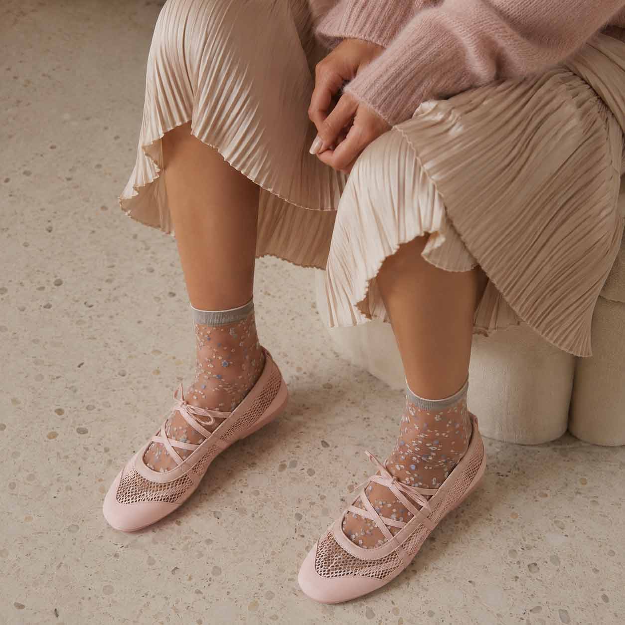 Różowe siateczkowe sneakeriny z paskami i przezroczystymi skarpetkami - zbliżenie na modny detal lata 2026