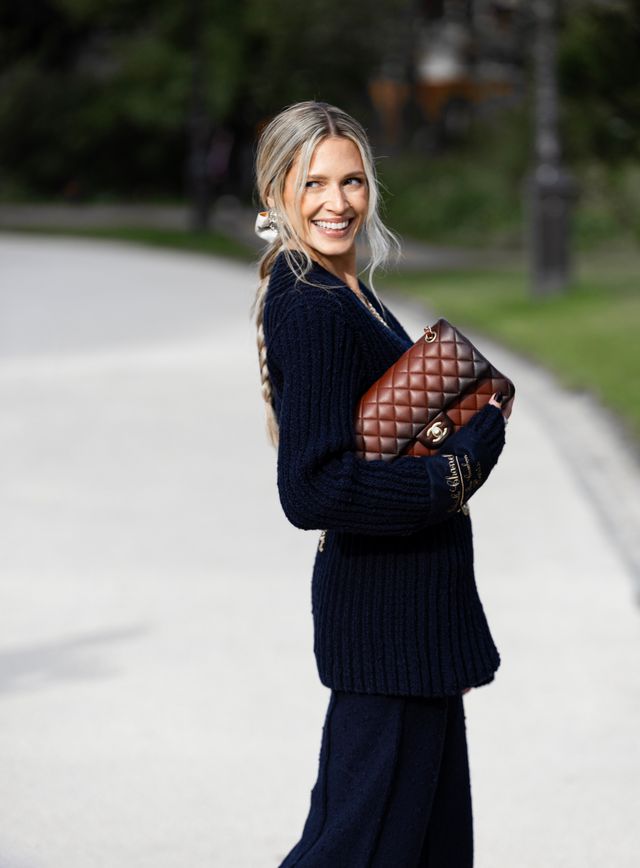 Street style z brązową pikowaną torebką Chanel noszoną do granatowej dzianiny