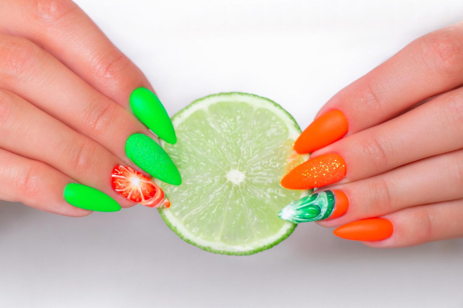 kobiece dłonie z letnim pomarańczowo-zielonym manicure z owocowymi wzorami