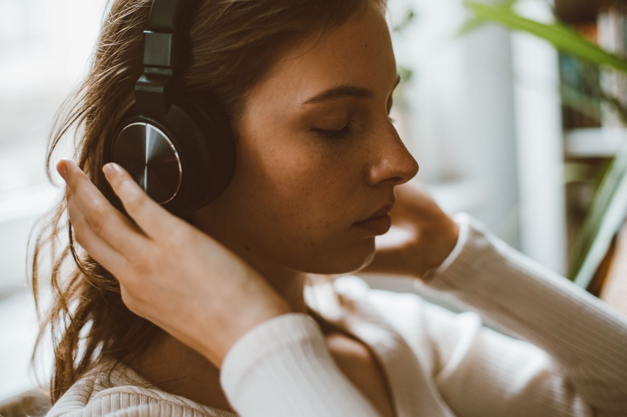 kobieta słuchająca audiobooka przez słuchawki
