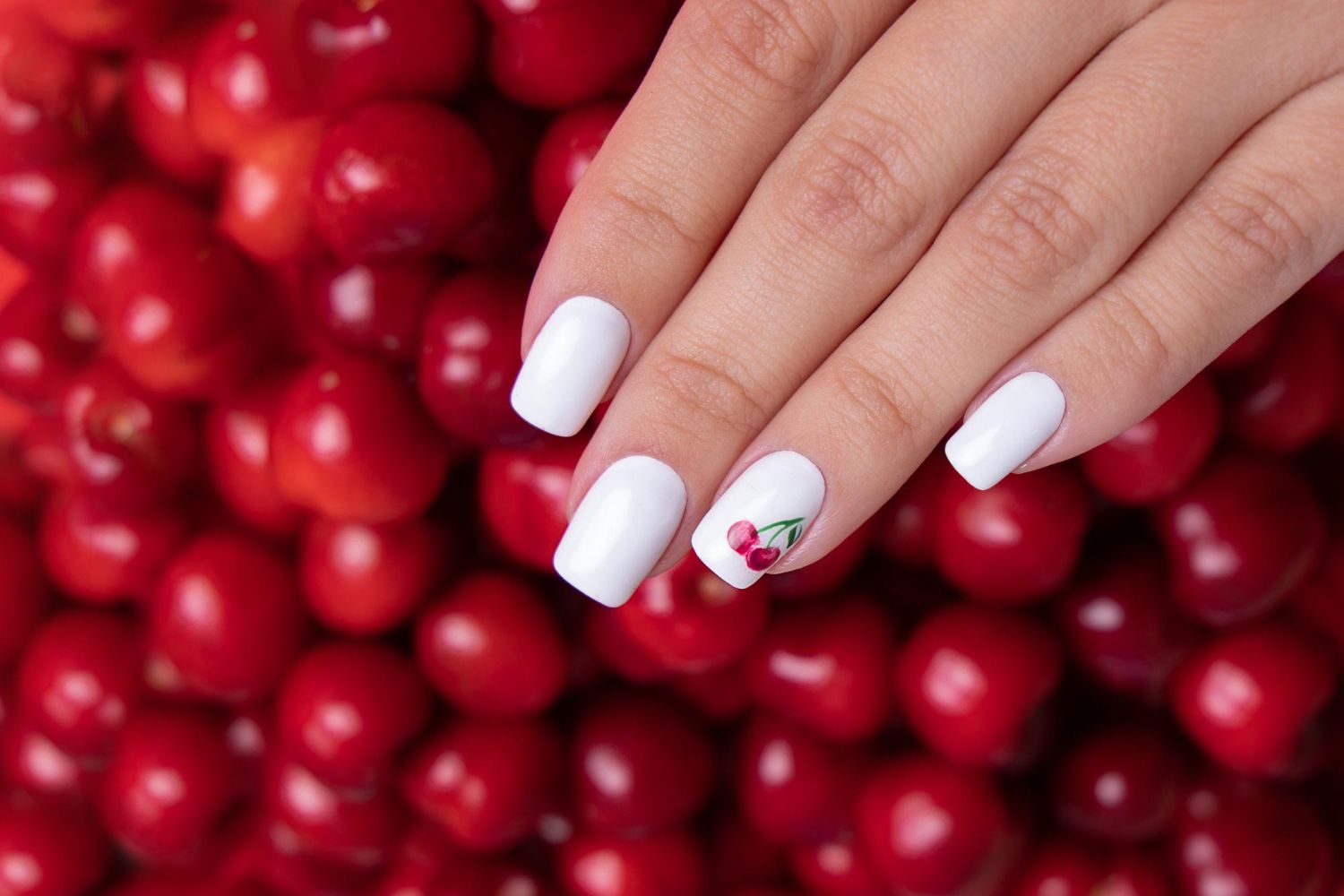 letni manicure z motywem czerwonych wiśni na paznokciach
